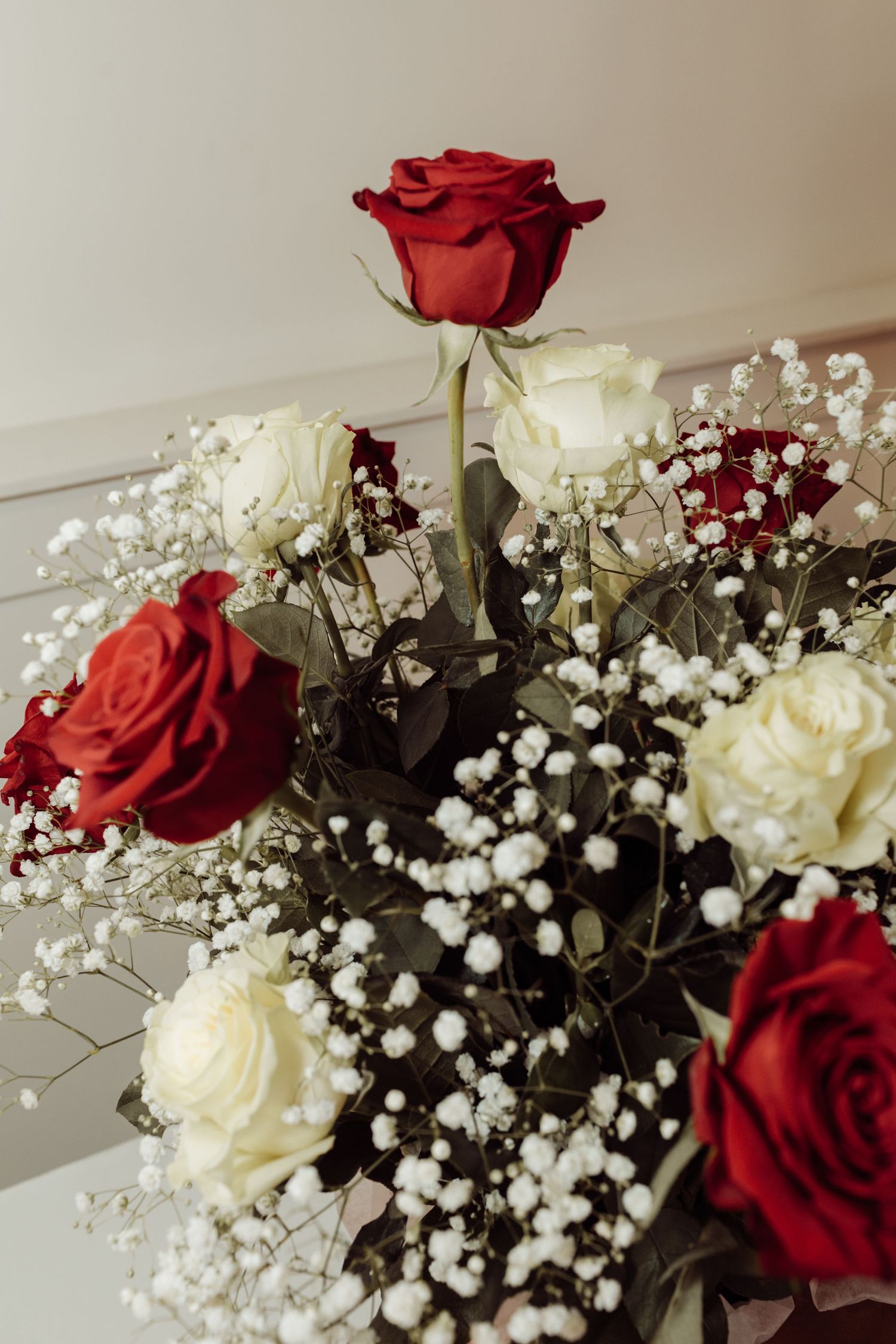 Close-up of a beautiful bouquet featuring red and white roses with delicate baby's breath accents.