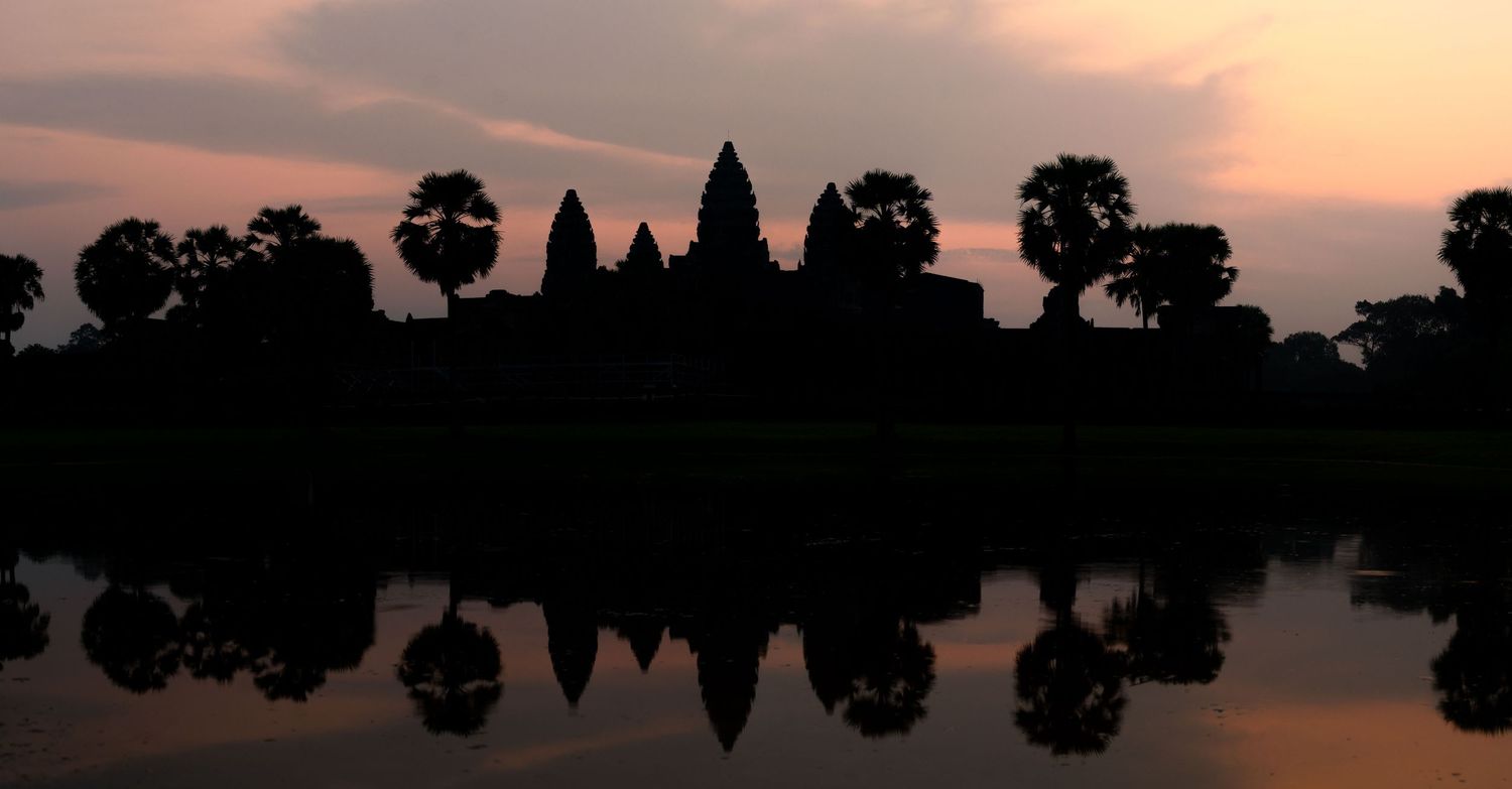 Ancient temple silhouettes against a dusky sky in Southeast Asia.