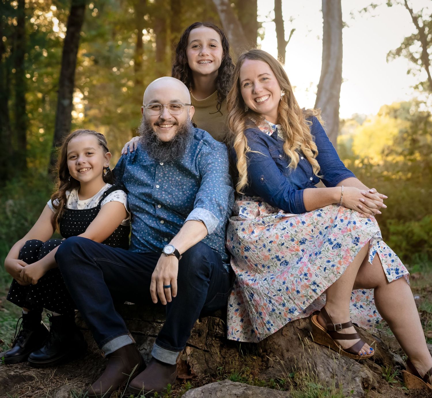 Lifestyle family photography in Lincoln, Alabama featuring a family of four in a natural outdoor setting at golden hour.