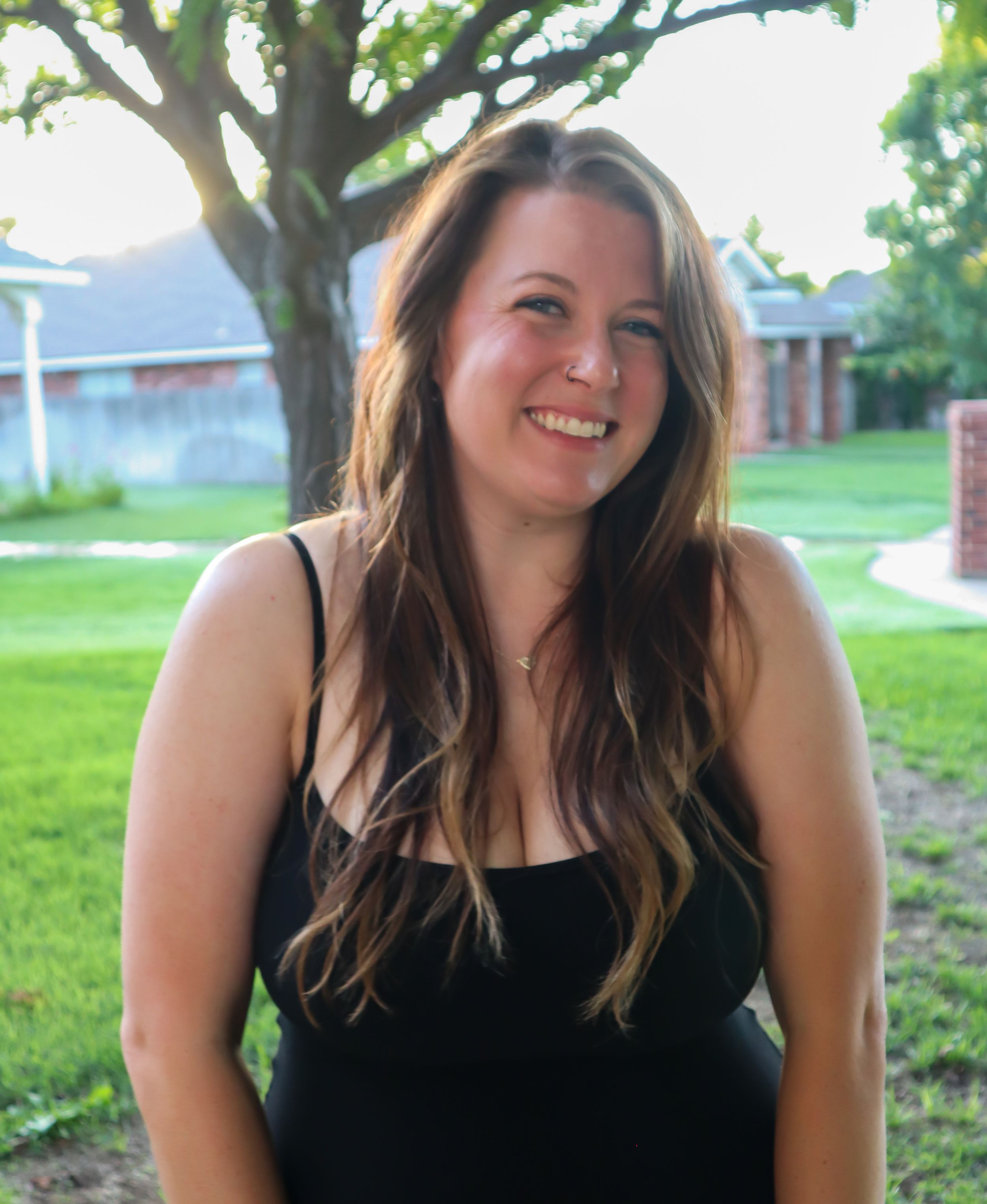 Outdoor summer portrait with trees and houses in background.