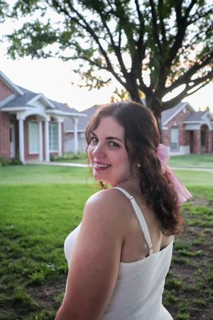 Candid outdoor portrait with residential homes in background at sunset.
