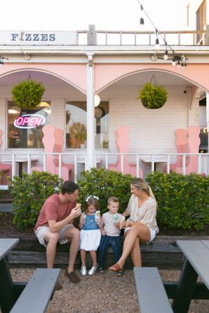 Family enjoying treats at a picnic table outside the Fizzes ice cream shop.