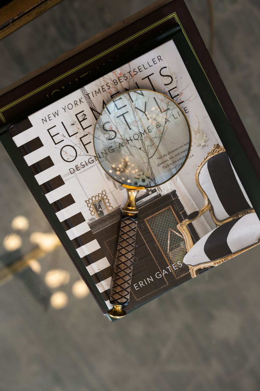 A New York Times bestseller book titled 'Elements of Style' with a decorative globe visible in the frame.
