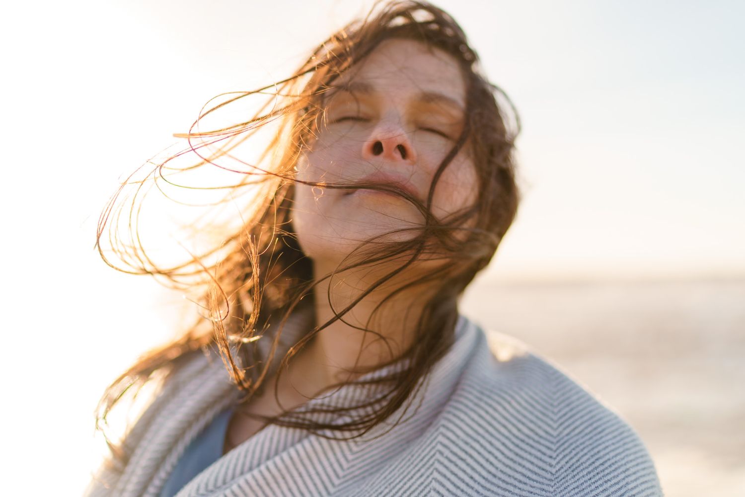 Woman enjoys the sun on the beach in Scheveningen during a photoshoot with photographer The Hague, Theo Manusaride.