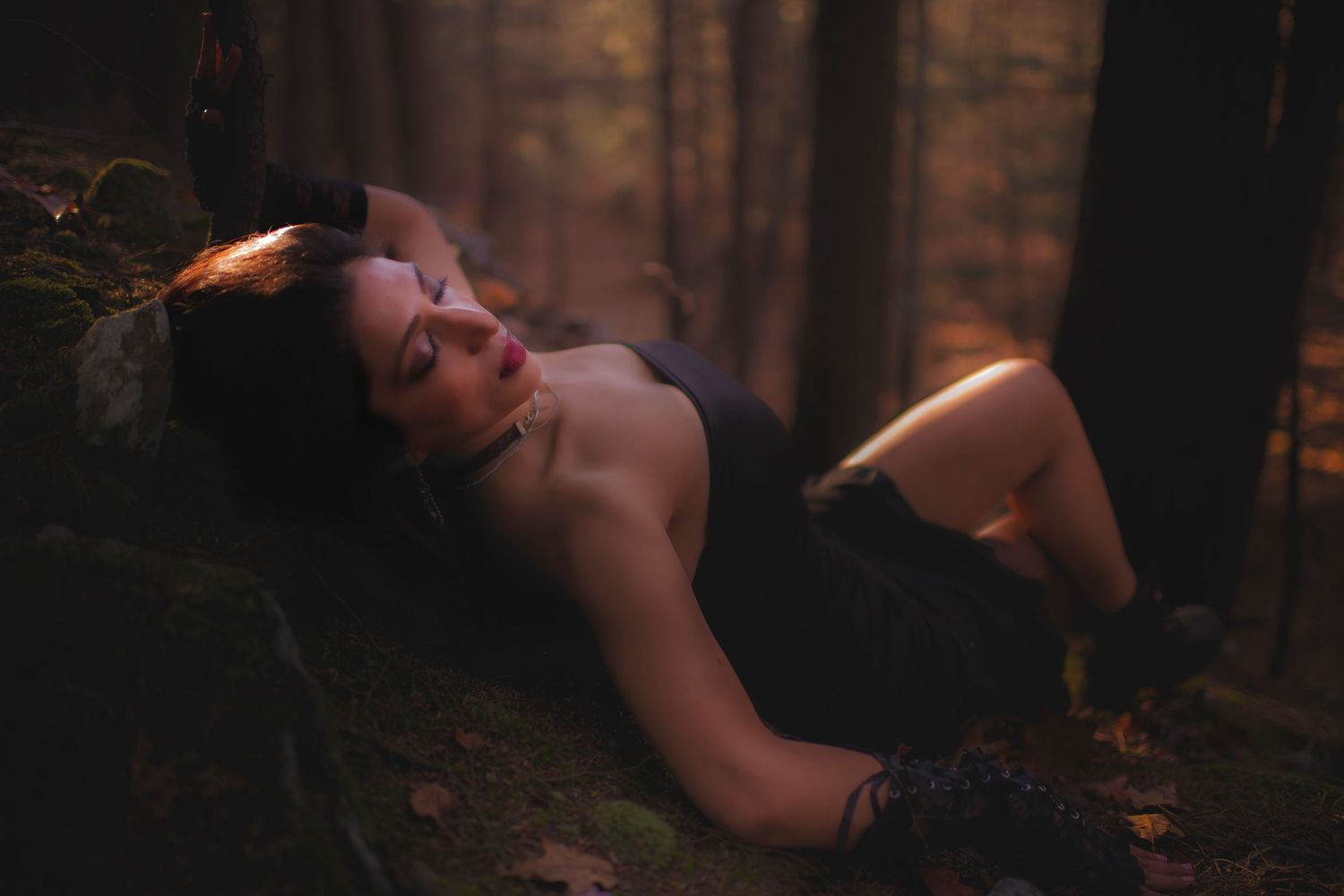 Moody forest portrait with warm sunset lighting and dramatic shadows.