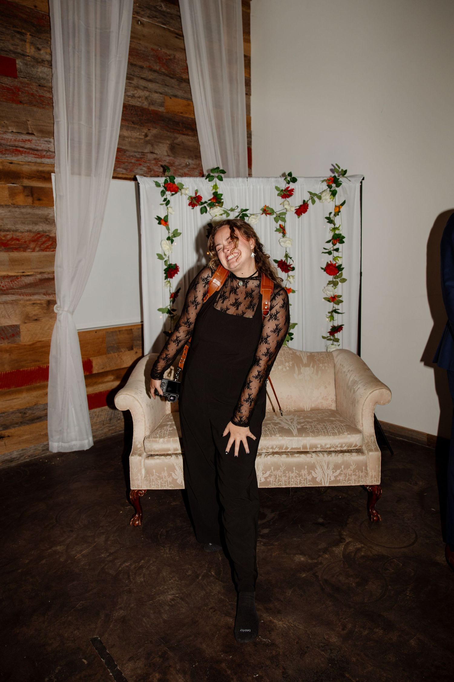 Elegant portrait in a rustic room with floral decorations and white curtains.