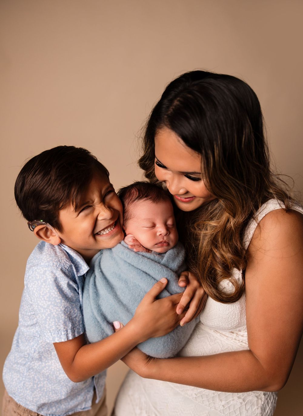 Joyful family moment with three people sharing tender embrace.
