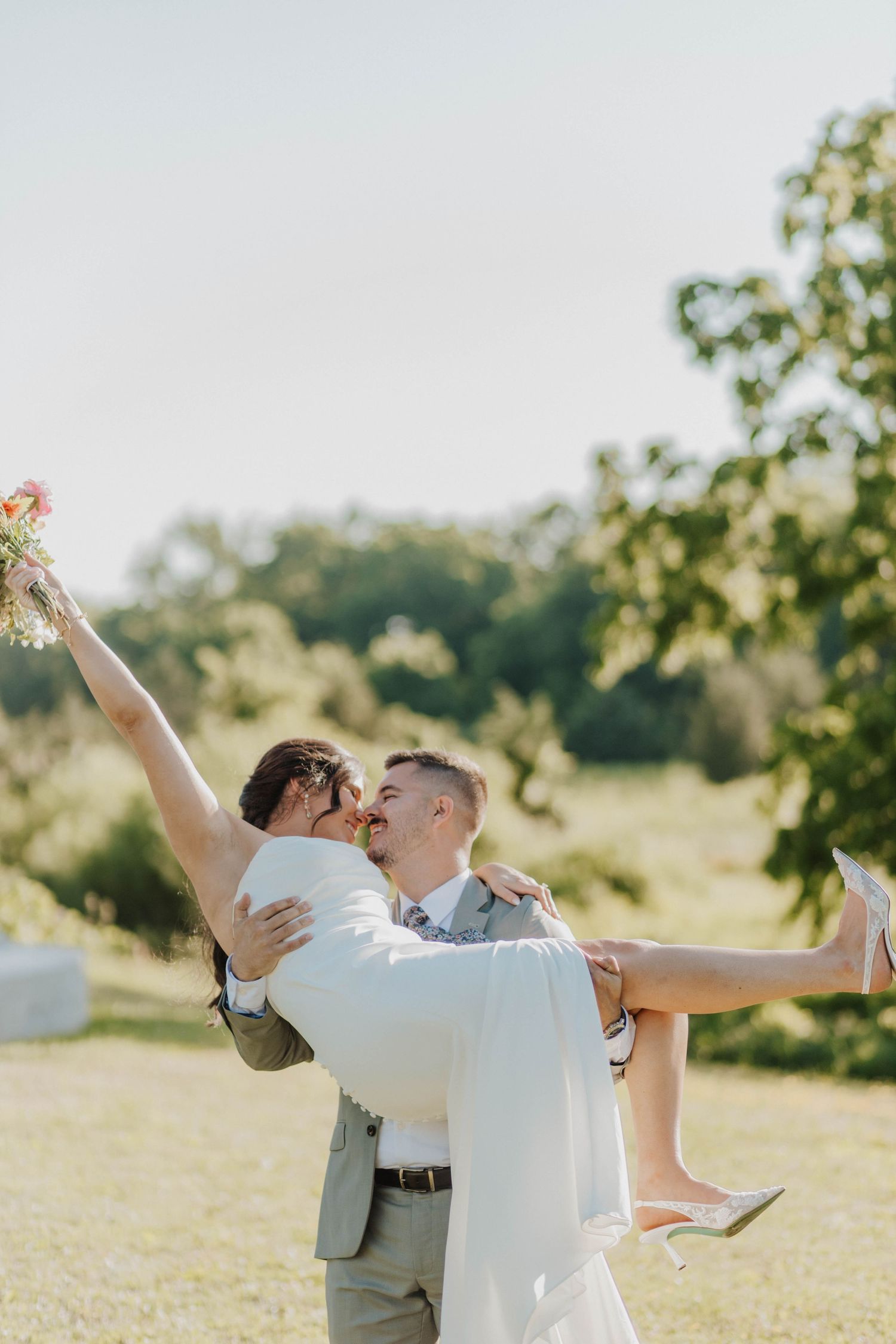 Intimate forest wedding portrait with soft lighting filtering through pine trees.