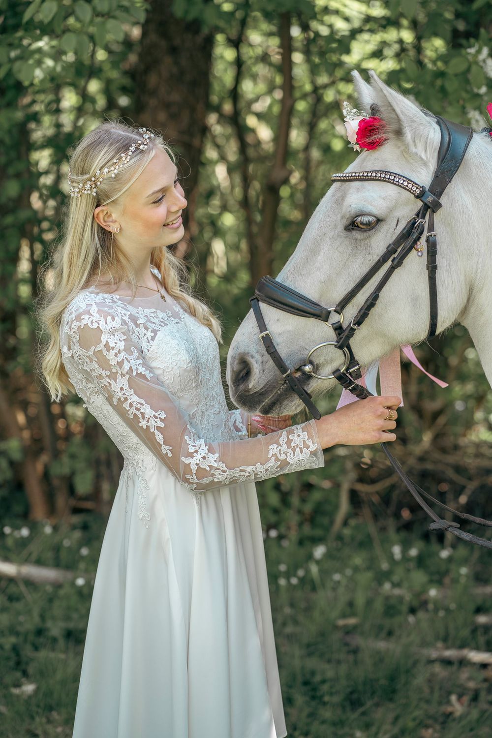 Konfirmand med hendes hest  ude i en skov