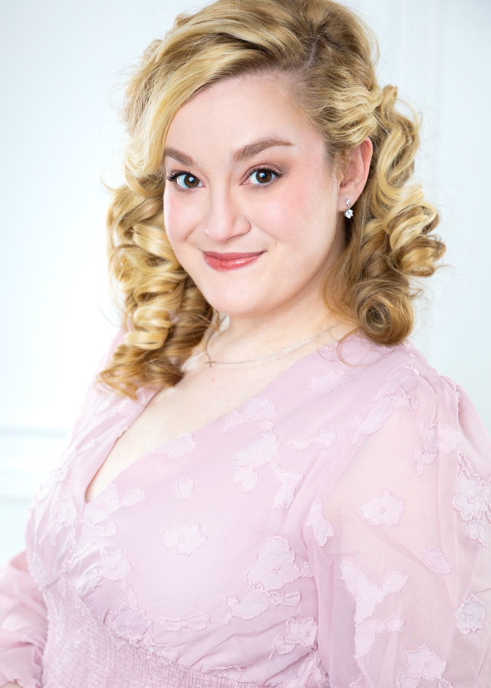 Glamour portrait series featuring soft pink lace dress against white background.