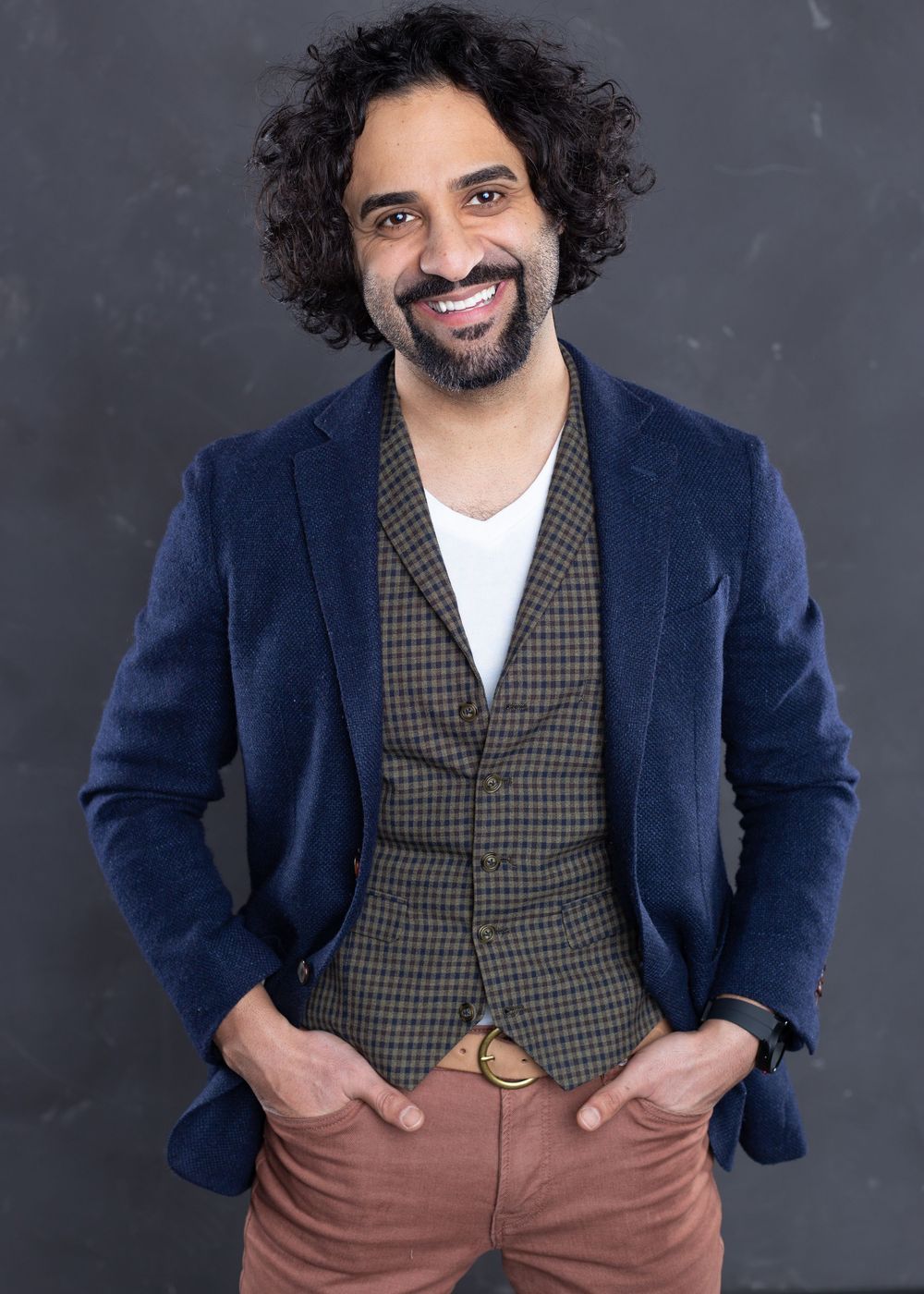 Professional photos of person in navy blazer and checkered vest against gray background.