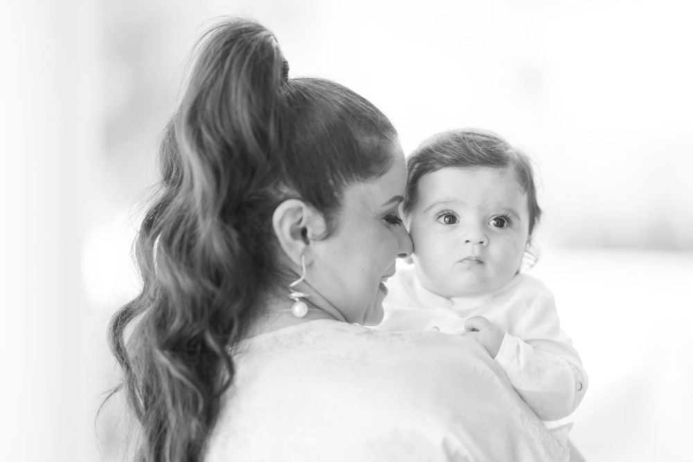 Soft black and white portrait of parent and baby in intimate pose.