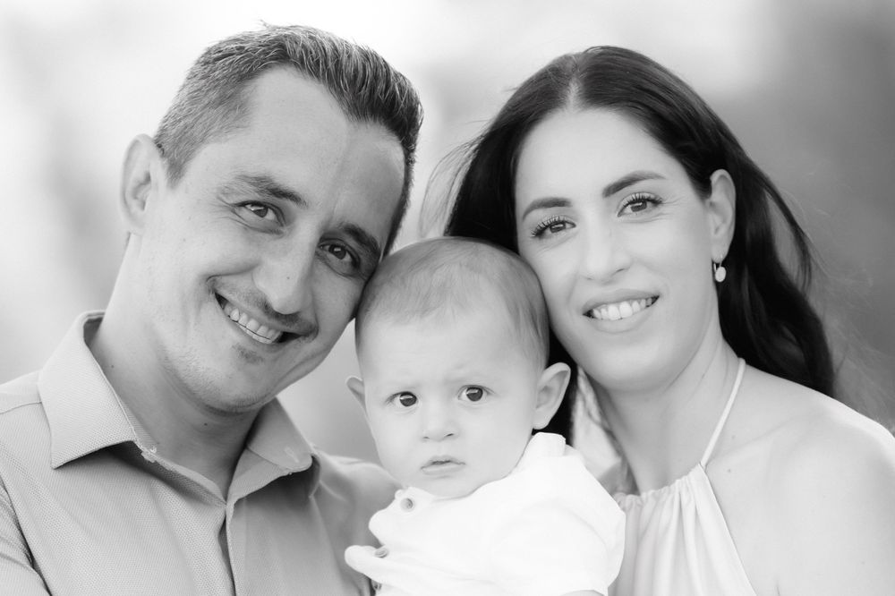 Classic black and white studio portrait of a family with an infant.