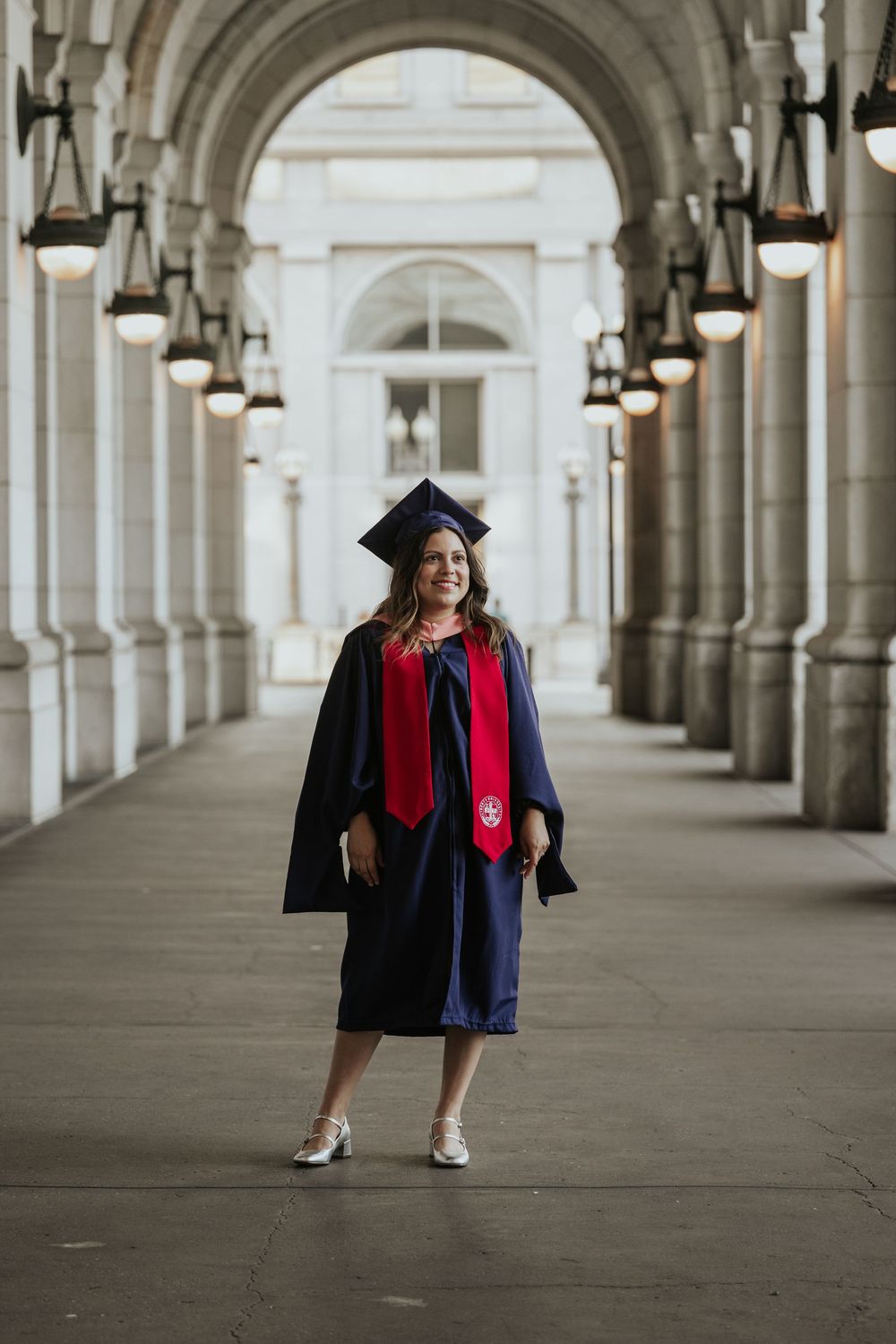 Three graduation photos show a graduate in cap and gown walking under ornate arched columns at sunset.