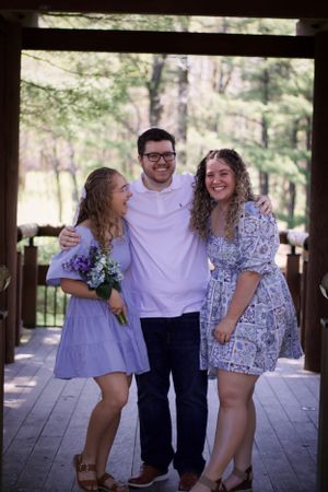 A family hugging eachother outside with trees in the background for a family session in Edwardsville, Illinois