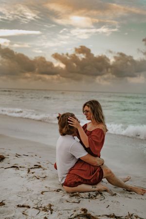 a couple sits on the beach in Anna Maria Island Florida