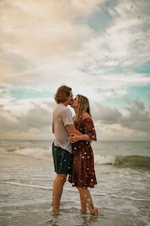 A couple kissing in the break of the waves on the beach in Anna Maria Island Florida