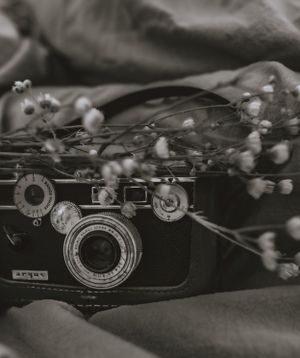 a vintage film camera with a bundle of flowers placed on top shot in black and white in Western North Carolina just outside of Asheville