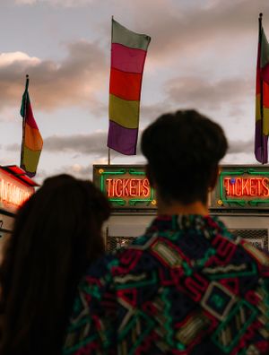 two peoples heads with a flag on the ticket stand at the carnival