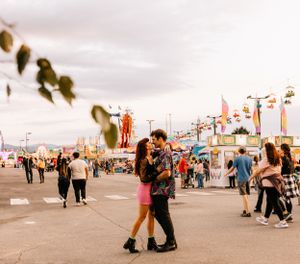 a couple share a kiss at the carnival