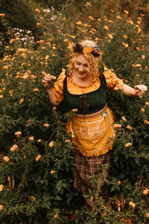 a girl in a yellow dress stands in a bush that is blooming with yellow flowers in Western North Carolina near Asheville and Boone