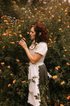 a girl dressed as a hobbit stands in a bush full of yellow flowers in Western North Carolina near Asheville