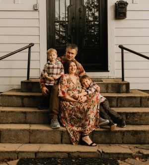 a young family sit together on the stairs