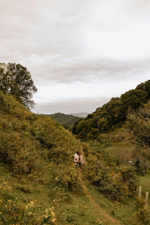 a couple walking a path in a green lush mountain town in Western North Carolina near Asheville