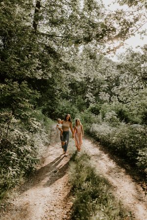 a mom walks along a dirt road with her two children in Western North Carolina just outside of Asheville