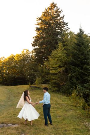 a bride and groom stand on the Blueridge Parkway in Asheville North Carolina as the golden light shines on the pines