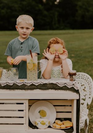two children being silly while making lemonade outdoors