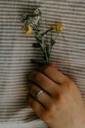 a hand holds a small bundle of yellow flowers against a striped shirt in Western North Carolina just outside of Boone North Carolina