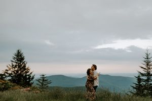 a couple hugging in front of mountain views in Western North Carolina just outside of Asheville on the Blueridge parkway