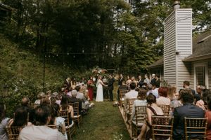 a bride and groom stand in front of their wedding guests in an intimate backyard wedding