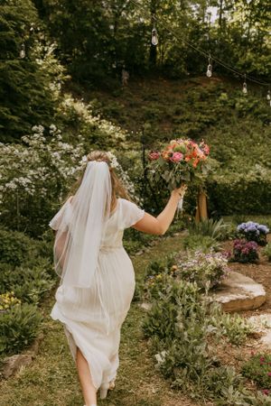 a bride marches with a colorful bouquet through her garden celebrating her marriage
