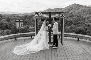 in black and white a bride and groom stand at the alter on a large deck overlooking the mountains of Western North Carolina
