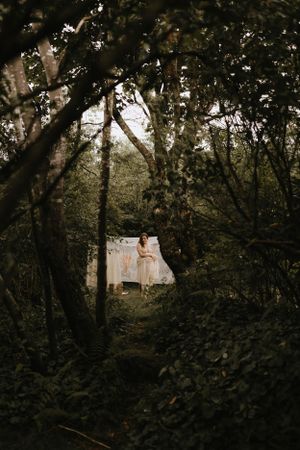 a woman hangs laundry on the line in the woods in Western North Carolina near Asheville