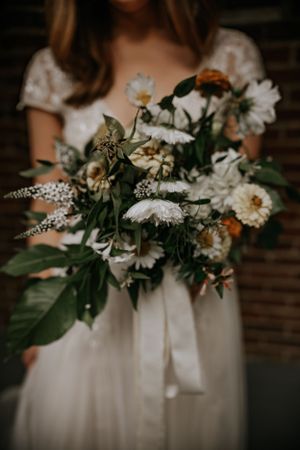 a bride shows off a custom bouquet from a local shop in Western North Carolina just outside of Asheville