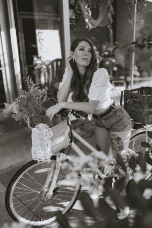 a black and white photo of a woman on her vintage bike with baskets in Western North Carolina near Asheville
