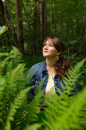a vivid green fern patch with a young woman in the middle in Western North Carolina near Asheville