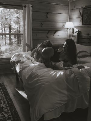 a monochrome shot of a couple snuggled on a bed with coffee in Western North Carolina near Asheville and Boone