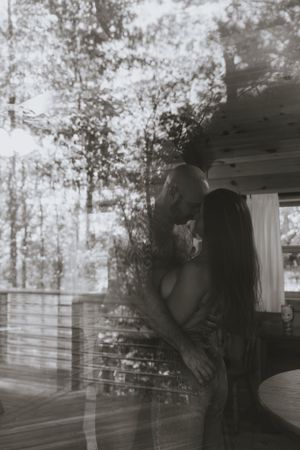 the reflection of trees and a couple in an intimate embrace in monochrome in Western North Carolina near Asheville and Boone