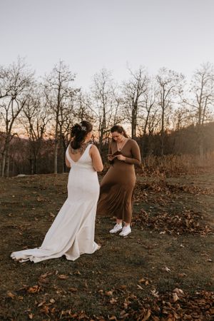 two brides sharing their vows in an open field surrounded by a line of trees in Western North Carolina near Asheville North Carolina