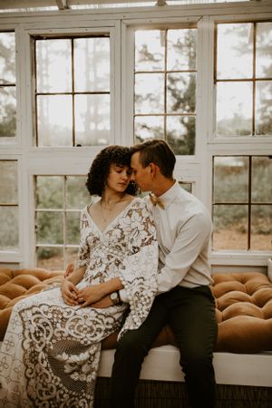 a couple snuggle up in a greenhouse in Western North Carolina just outside of Asheville