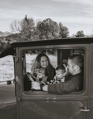a monochrome shot of a family in a vintage truck