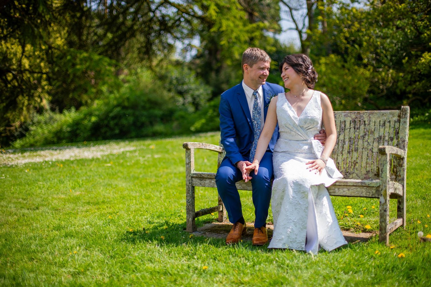 Bride and groom on bench at Follaton House Devon