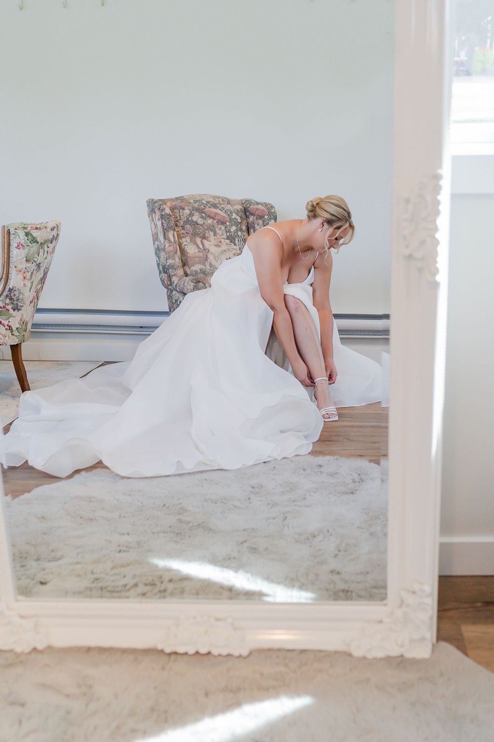 Multiple shots of a wedding dress being adjusted on a light-colored carpeted floor in a bright interior space.