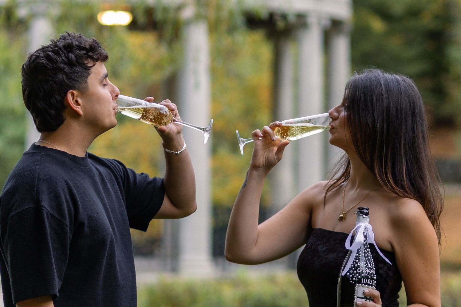 Newly engaged couple enjoying champagne at Slater Park in Rhode Island after their proposal.
