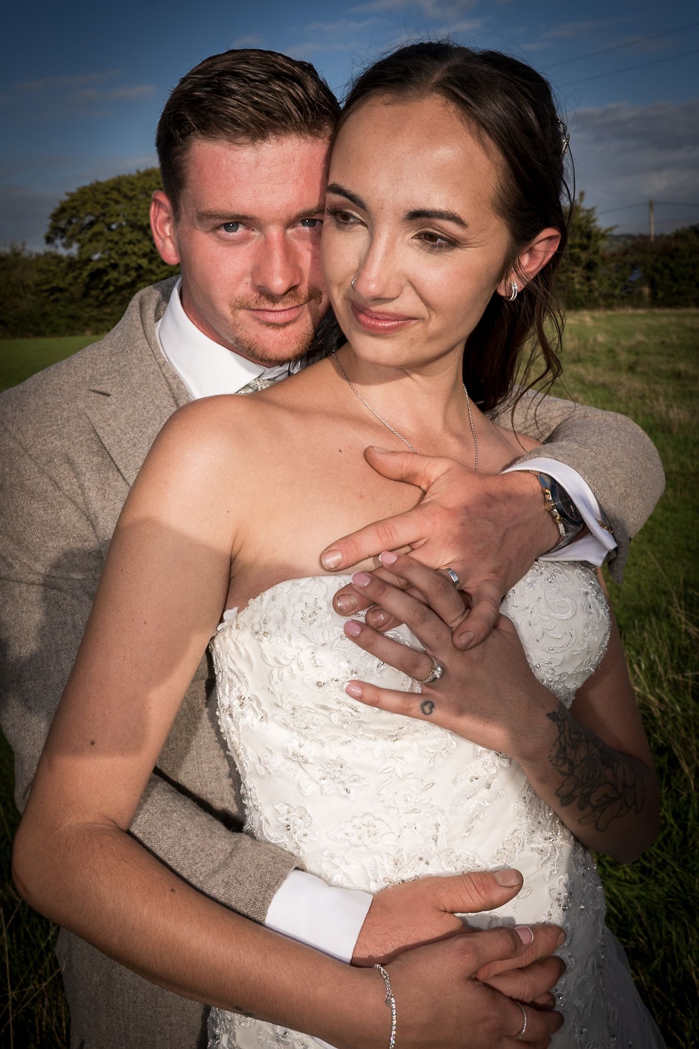 Intimate wedding portraits show tender moments between newlyweds in an outdoor setting.