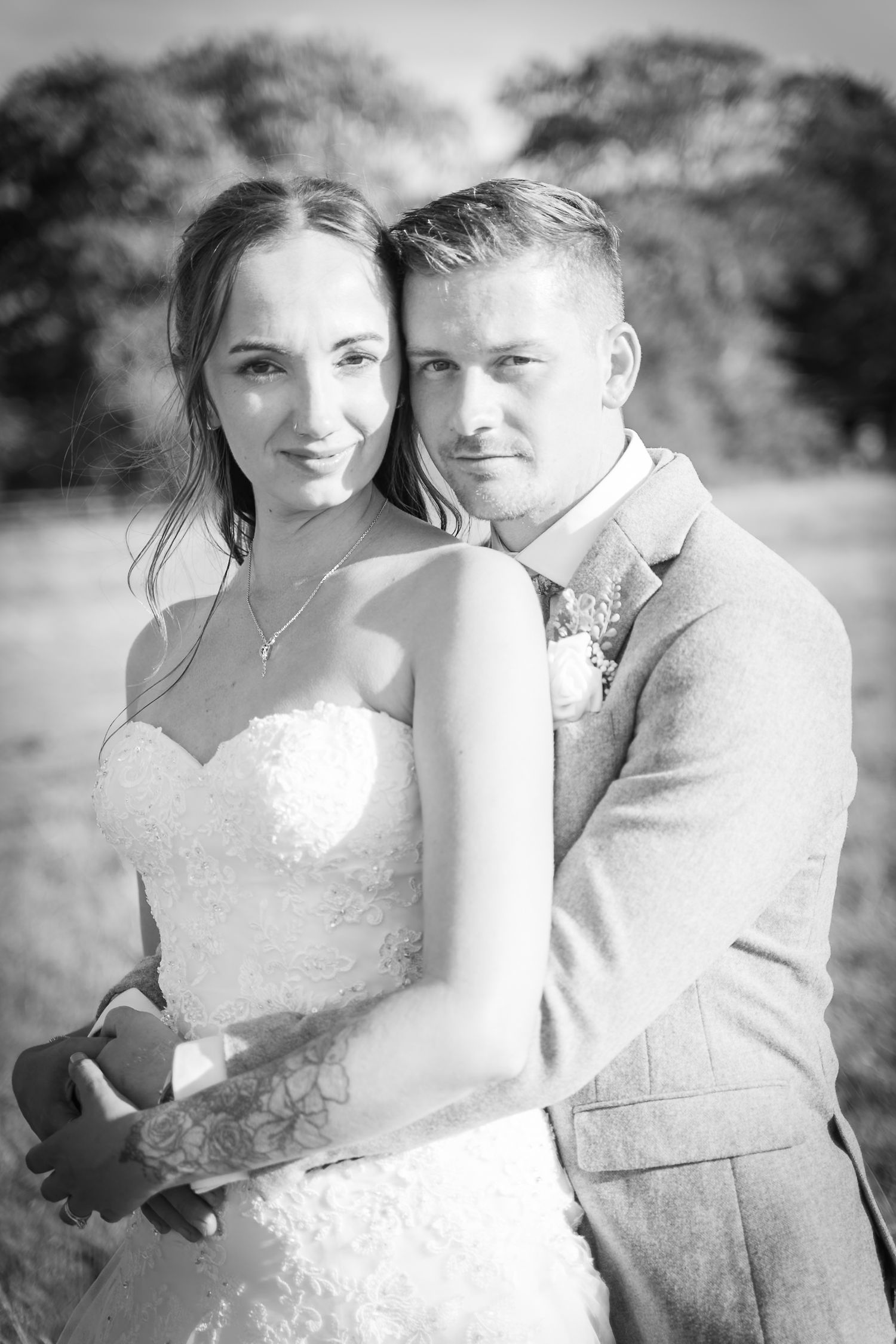 Black and white wedding portraits capture romantic moments in a natural outdoor setting.